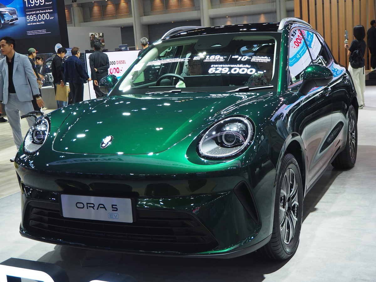 A green GWM Ora 5 Ultra on a motor show stand.