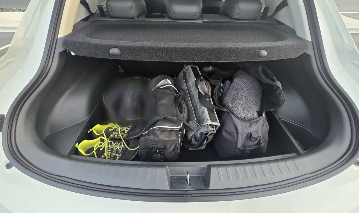The Ora 5's boot with four gym and travel bags and a pair of shoes in it.